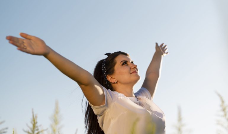 young-woman-holding-her-arms-air-looking-sky